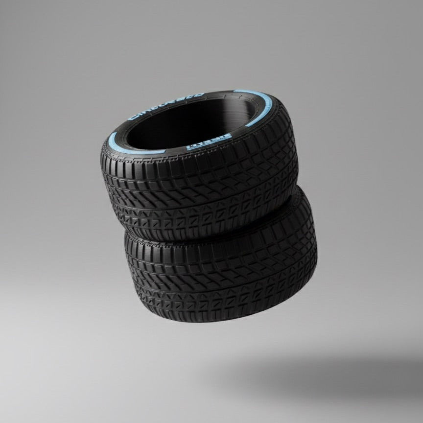 Three black tires stacked on a gray background